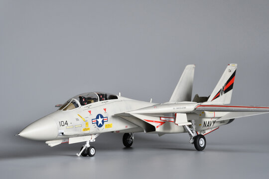 Florence, Italy - April 1th 2026: Scale model of a fighter plane F-14A Tomcat on a grey background. Toy.