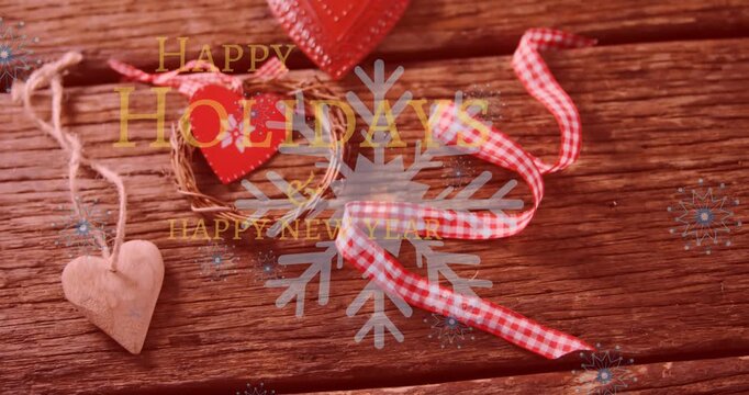Animation of happy new year and holidays text against christmas decorative items on wooden surface