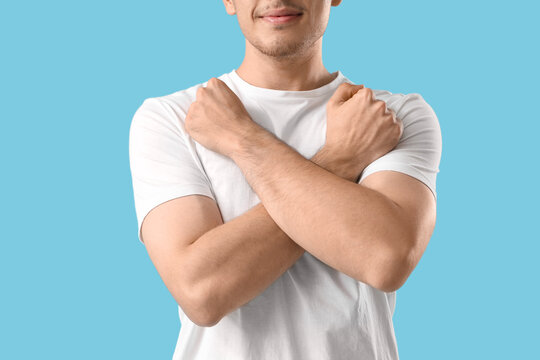Young man using sign language on blue background