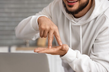 Young man using sign language while video chatting in kitchen, closeup © Pixel-Shot