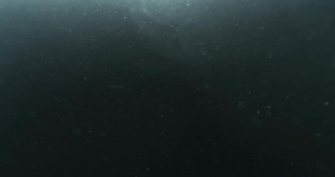 Cinematic 4K underwater footage captured from the POV of a deep-sea ROV drone, drifting through a vast, atmospheric water column filled with floating particles, soft light rays, and immersive depth&mdash;pe