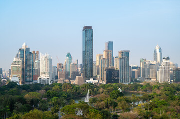 Obraz premium Urban skyline view of modern skyscrapers in a lush green city park daylight perspective urban development concept