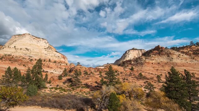 A stunning time-lapse shot capturing the movement of clouds over the towering, ancient sandstone formations of Zion National Park in Utah, USA.