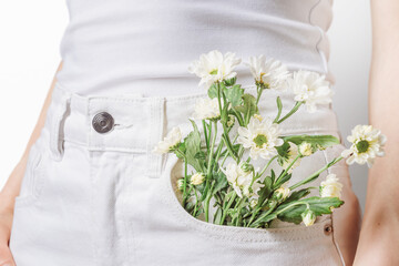 Soft minimalism concept with white daisies in front pocket, clean aesthetic, light tones, skincare and wellness style, calm modern lifestyle