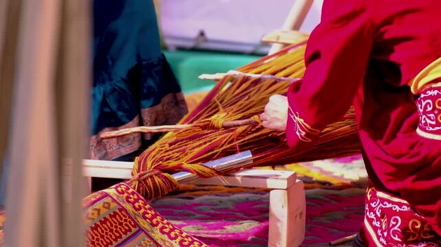Kazakh woman weaving traditional textile on loom in slow motion, cultural craftsmanship