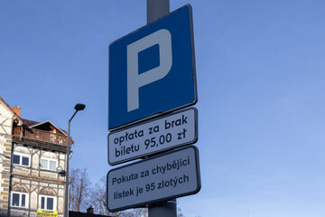 Fototapeta premium Blue parking sign with a white P symbol clearly warns drivers about a parking fee, highlighting urban traffic regulations and potential fines for violations