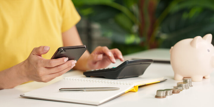 Woman managing finances with phone and calculator