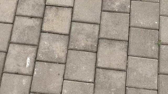 Top view of the surface of a pedestrian path with paving slabs. New cobblestone pavement close up. Traditional stone pavement. 