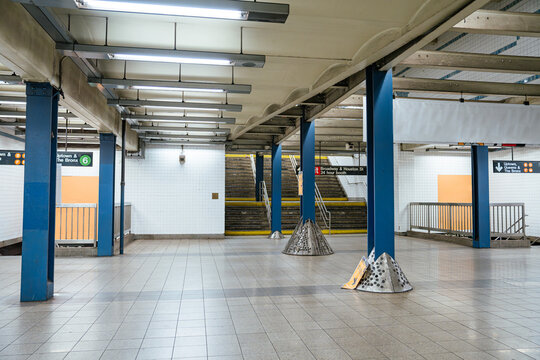 New York City, New York, USA - 08.03.2024: Underground New York City subway platform with stairs leading to street exit. Metro station interior with tiled walls and transportation signage.