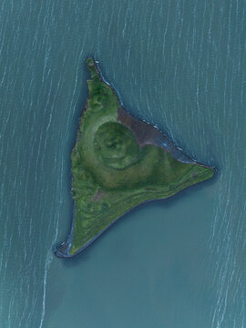 Aerial view of a verdant, triangular island rises from the serene, blue waters of Lake Myvatn, Thingeyjarsveit, Iceland.