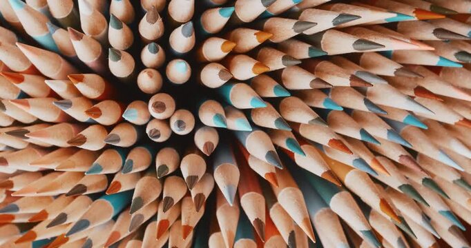 Detailed macro view of a pile of sharpened drawing pencils in vibrant colors. Sharp tips and rich wooden texture, perfect stationery composition for school and creativity 4K.