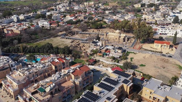 Aerial drone view showing archaeological ruins alongside modern buildings in Paphos, Cyprus