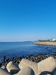 Fototapeta premium The blue Jeju sea with a breakwater.