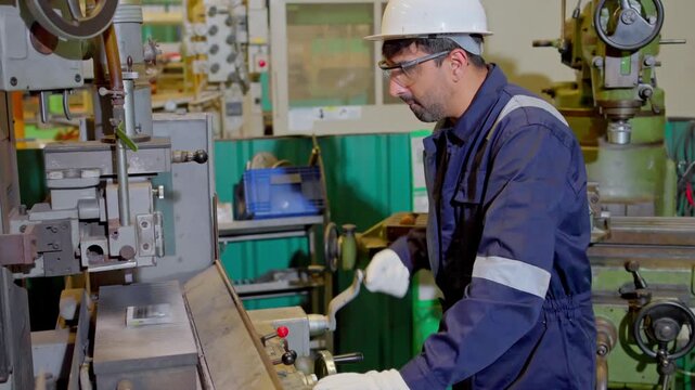 Industrial worker operating machinery in manufacturing facility action shot workshop environment focus on precision