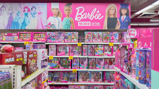 Barbie displays in a toy aisle featuring various dolls and accessories in a vibrant store setting
