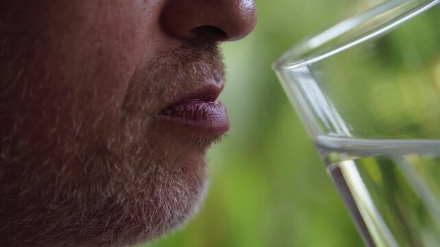 Man drinking water from glass, close-up hydration concept
