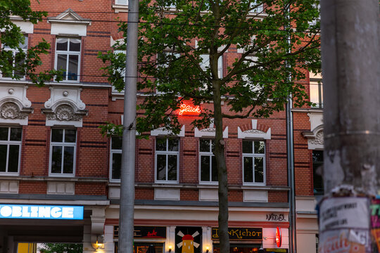Historische Backsteinarchitektur mit Gesch&auml;ften und Baum in europ&auml;ischer Innenstadt bei Abendd&auml;mmerung
