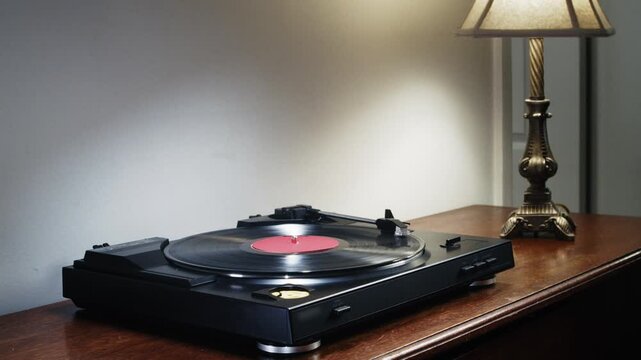 Close-up of a vintage turntable with a black vinyl record rotating smoothly under red neon light. Warm analog sound plays, creating a perfect old school vibe and nostalgic music atmosphere 4K.