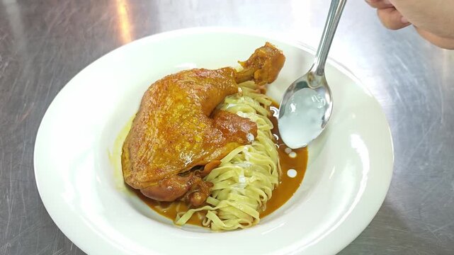 Modern Khao Soi Kai, Northern Thai style chicken curry noodles served as fusion pasta on white plate.