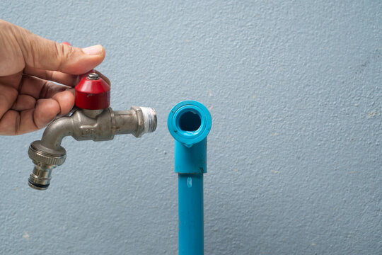 Plumber fixing leaked outside tap with thread tape.