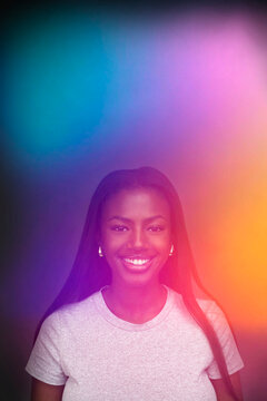 Aura photography of smiling young woman's portrait with long hair against studio background