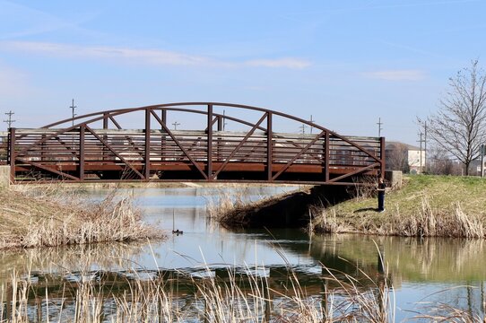 The steel footbridge in the park on a sunny day.