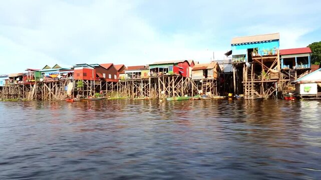 A row of traditional wooden and corrugated metal houses built high on stilts stands along the lake Tonle Sap in Cambodia