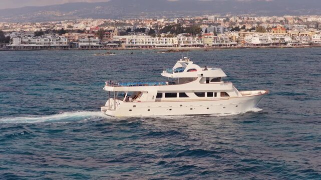 Aerial drone view of luxury yacht moving across blue Mediterranean Sea near Paphos, Cyprus