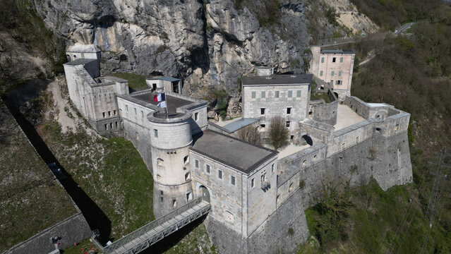 Aerial view of the imposing Fort l'Ecluse clinging to the rugged cliffs, a fortress of stone against a backdrop of natural grandeur, Leaz, Auvergne-Rhone-Alpes, France.