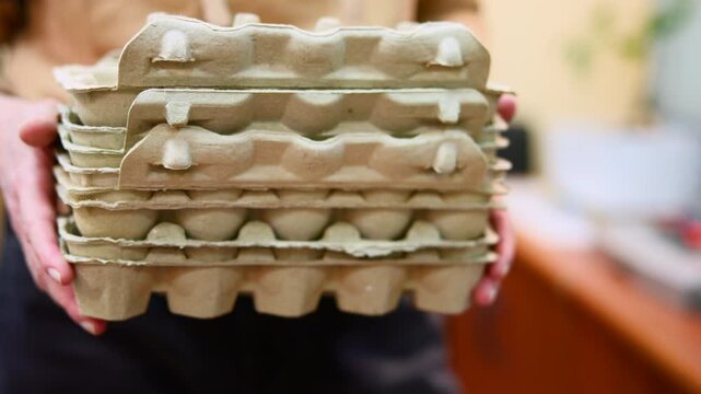 Woman Organizing Supplies. Caucasian Woman Methodically Stacks Recycled Pulp Trays On Countertop Near Basin . Media