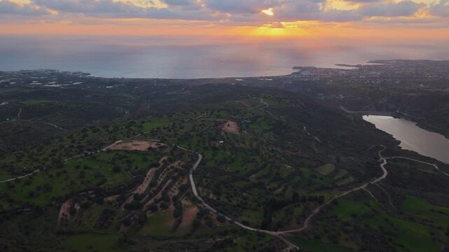 Aerial drone view of green hills and coastline during sunset in Cyprus