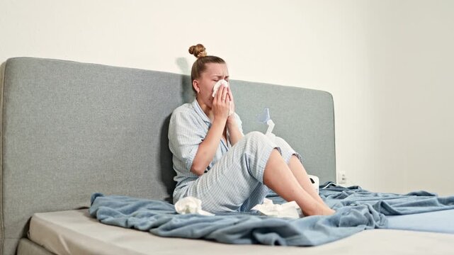 Young woman blowing her nose into a napkin during illness. Woman with respiratory illness and runny nose. SARS in woman with fever and snot.