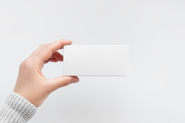 Obraz premium Hand Holding Blank White Square Cardboard Pill Box Mockup 