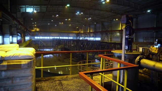 Industrial Processing Facility Interior with Chemical Reagent Bags on Pallet and Heavy Machinery. Mining Plant Hall with Pipes and Equipment.