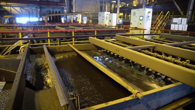 Wet Coal Concentrate Discharging from Belt Conveyor into Trough at a Processing Plant. Industrial Mineral Separation Equipment in a Coal Enrichment Facility.