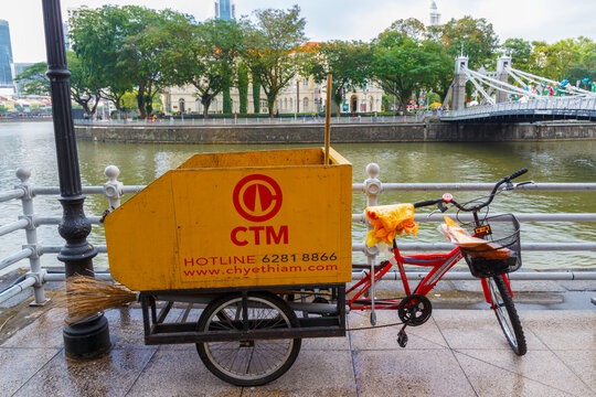 Singapore - 25 December, 2025: A specialized street cleaning bicycle from CTM. Used to remove trash in areas difficult to reach for large equipment. Equipped with yellow trash container and brush