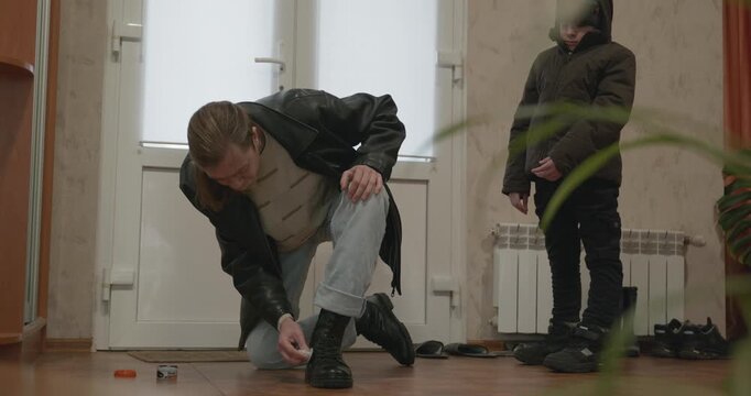 Man and child put on footwear winter shoes. 4K 10-bit