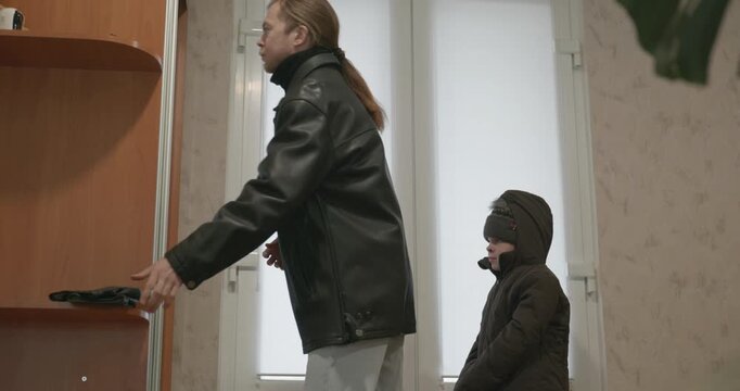 Man and child put on footwear winter shoes. 4K 10-bit