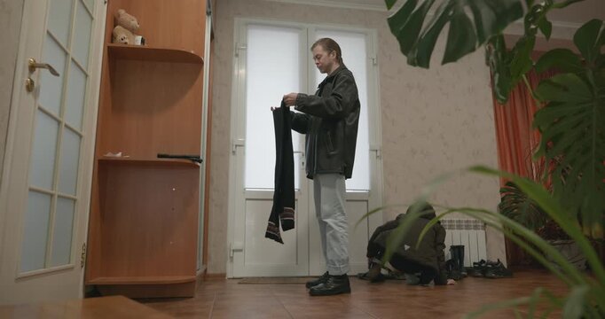 Man and child put on footwear winter shoes. 4K 10-bit