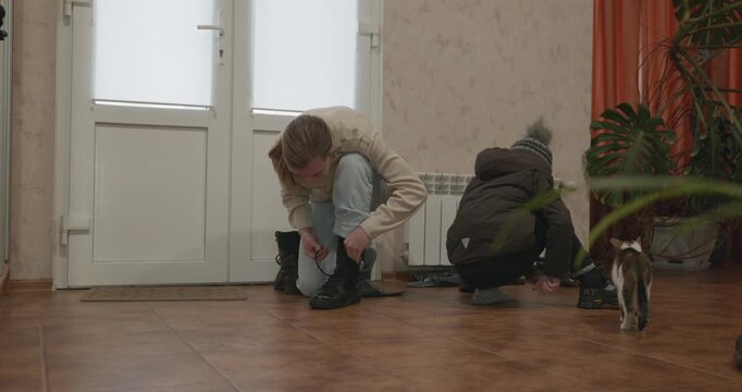 Man and child put on footwear winter shoes. 4K 10-bit