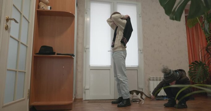 Man and child put on footwear winter shoes. 4K 10-bit