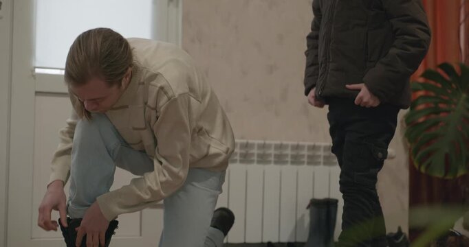 Man and child put on footwear winter shoes. 4K 10-bit