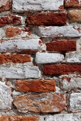 Obraz premium Old red brick wall with rough surface texture. Weathered stone masonry background for architectural design project. Rustic building construction material covering modern interior surface. Vertical