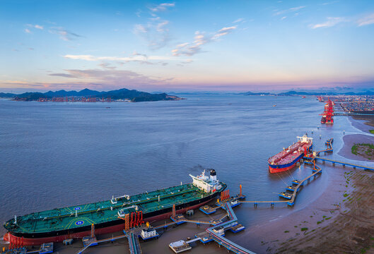Bird's eye view of large oil tankers docked at terminal pier in calm sea. Global maritime transport and shipping logistics business.