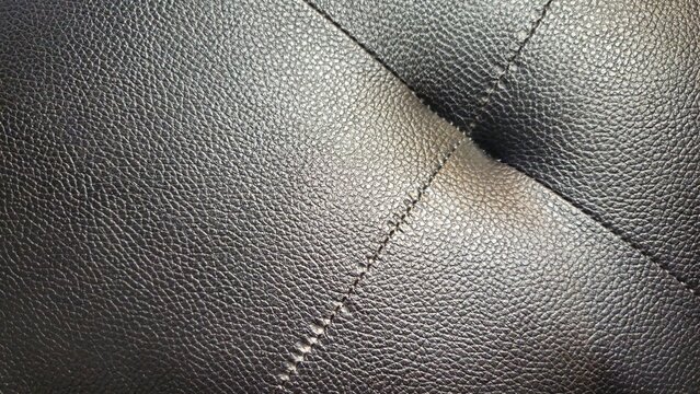 Textured Leather Elegance: A close-up shot of luxurious, stitched leather reveals the fine details of craftsmanship, inviting tactile contemplation of texture, pattern and form. 