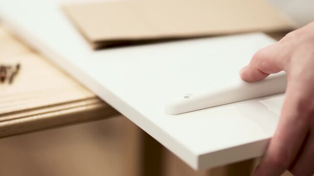  Man marking wall with pencil for shelf installation, DIY home improvement project, 4K 10 bit footage.