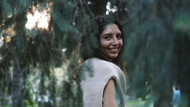 Portrait of a very beautiful young woman in a summer spruce forest at sunset.