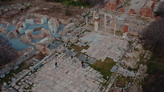 Aerial views of an ancient courtyard and monumental ruins in Ephesus, Izmir, Turkey. Stone pavements, columns and brick remains reveal the layered architecture of the archaeological site.