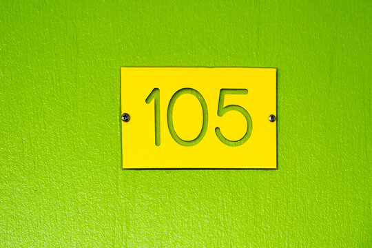 Minimal retro motel room number 105 sign in green and yellow