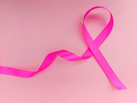 breast cancer ribbon. Pink ribbon, breast cancer awareness symbol, isolated on pink coloured background 